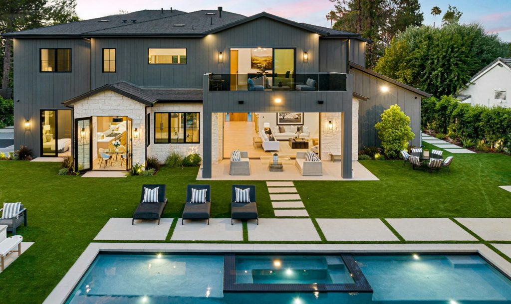 Luxurious modern house with backyard and pool at sunset.